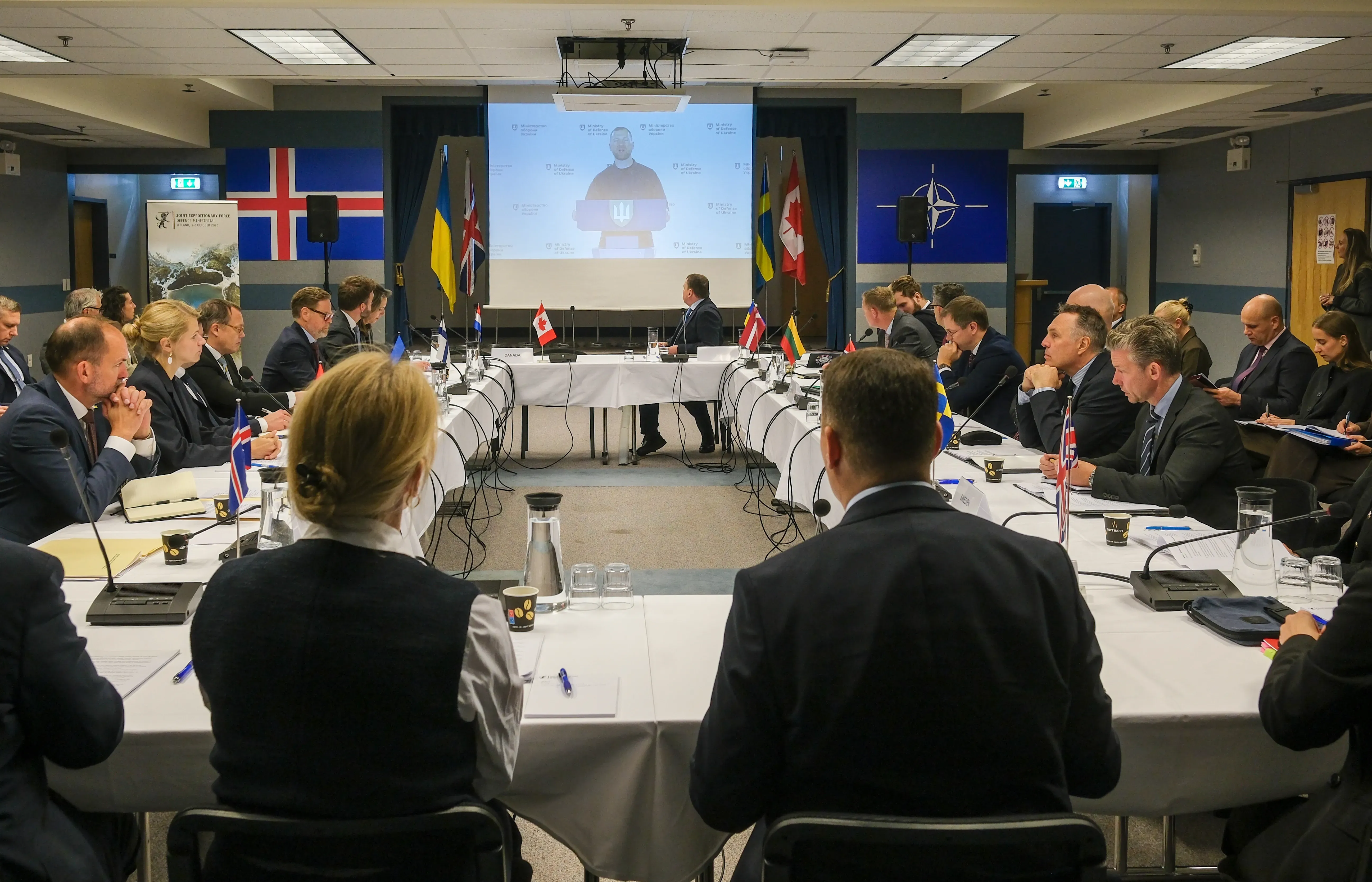 Reunión de la JEF con participantes sentados ante una videoconferencia.